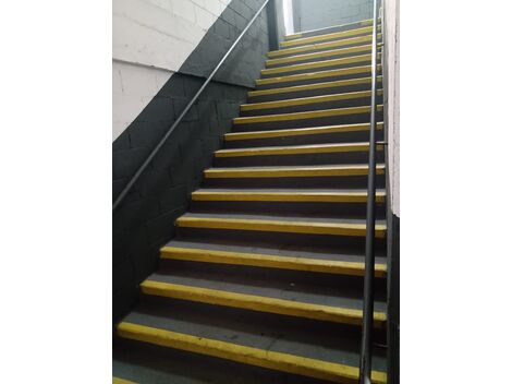"Corrimão metálico simples instalado na parede lateral."